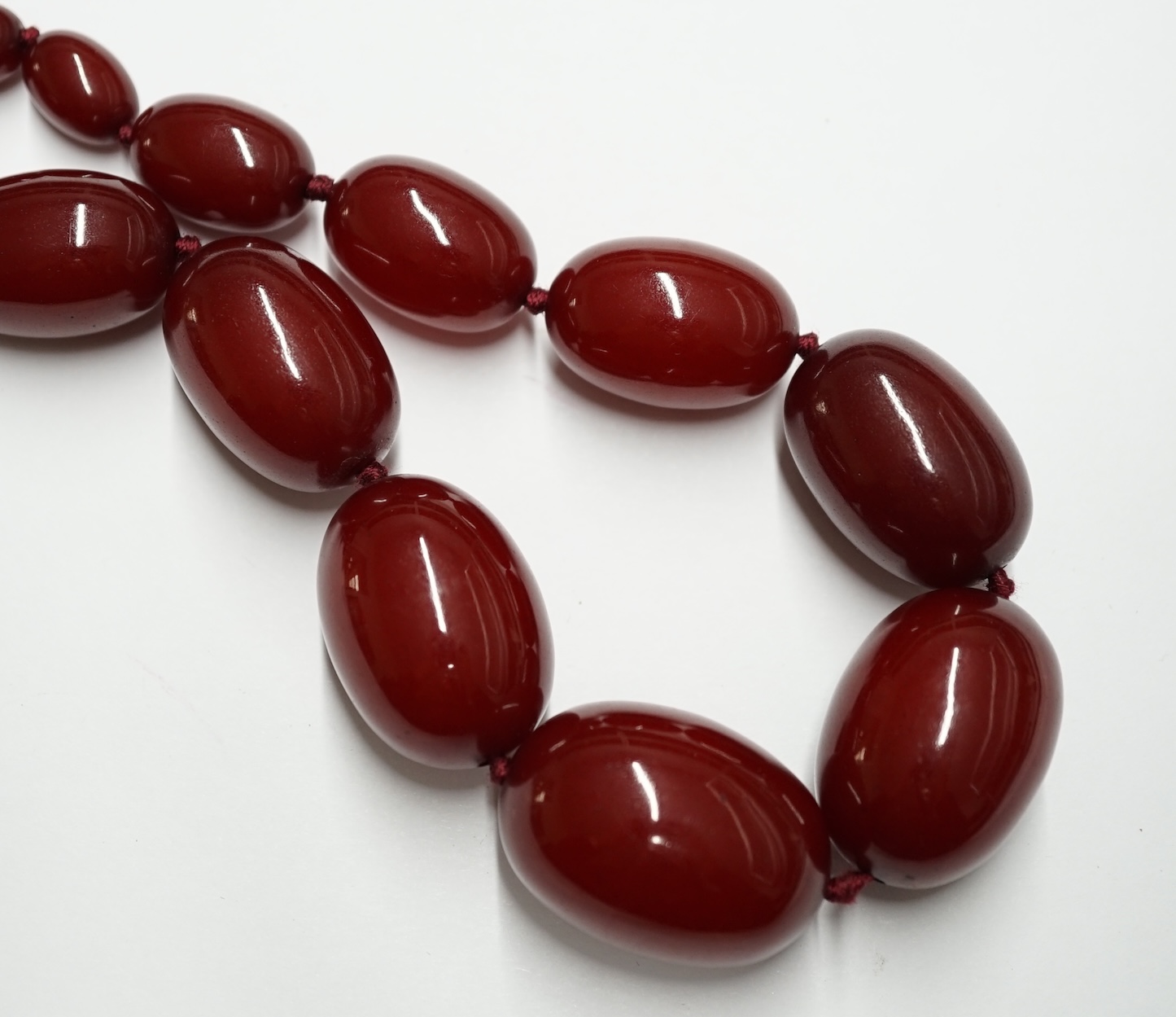 A single strand graduated simulated cherry amber bead necklace, 78cm, gross weight 87 grams. Condition - fair